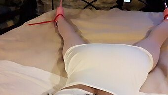 Laura, Adorned In A Seductive White Dress, Pink Tights, And Stilettos, Bound And Silenced On A Bed.